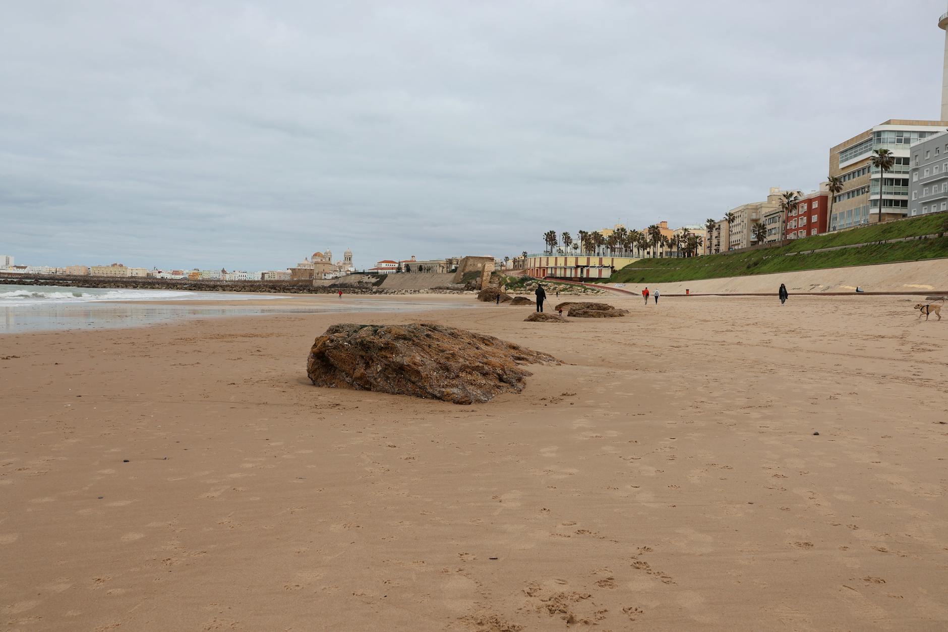 Coastal view of Cádiz, Spain with sandy beach, ocean, and historic city wall.