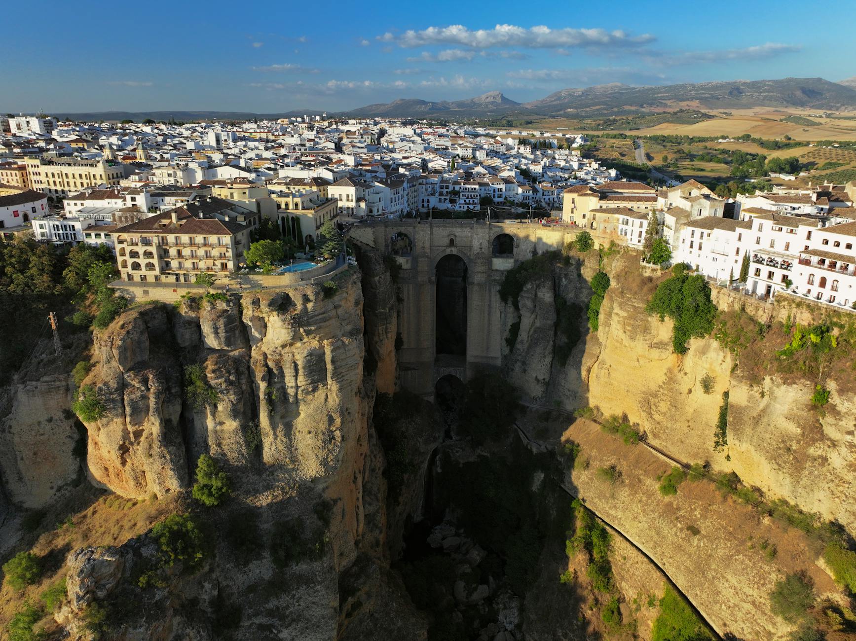Explore the breathtaking aerial view of Ronda's iconic Puente Nuevo bridge over the El Tajo Gorge.