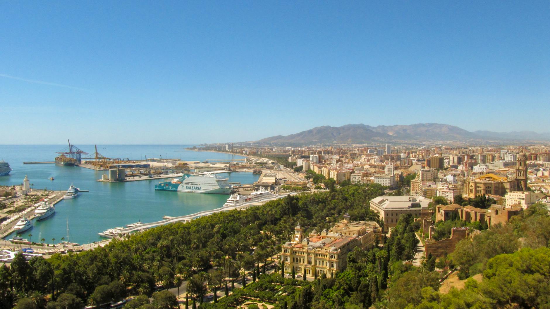 A beautiful aerial view of Malaga city with its port and coastal line, under a clear blue sky.