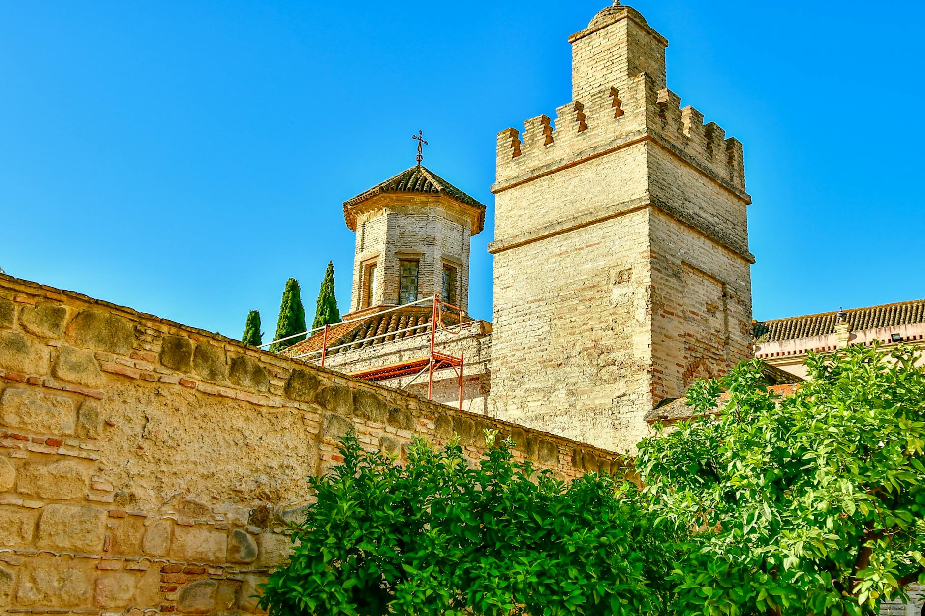 Stone fortress tower and wall in Jerez de la Frontera under a clear blue sky.