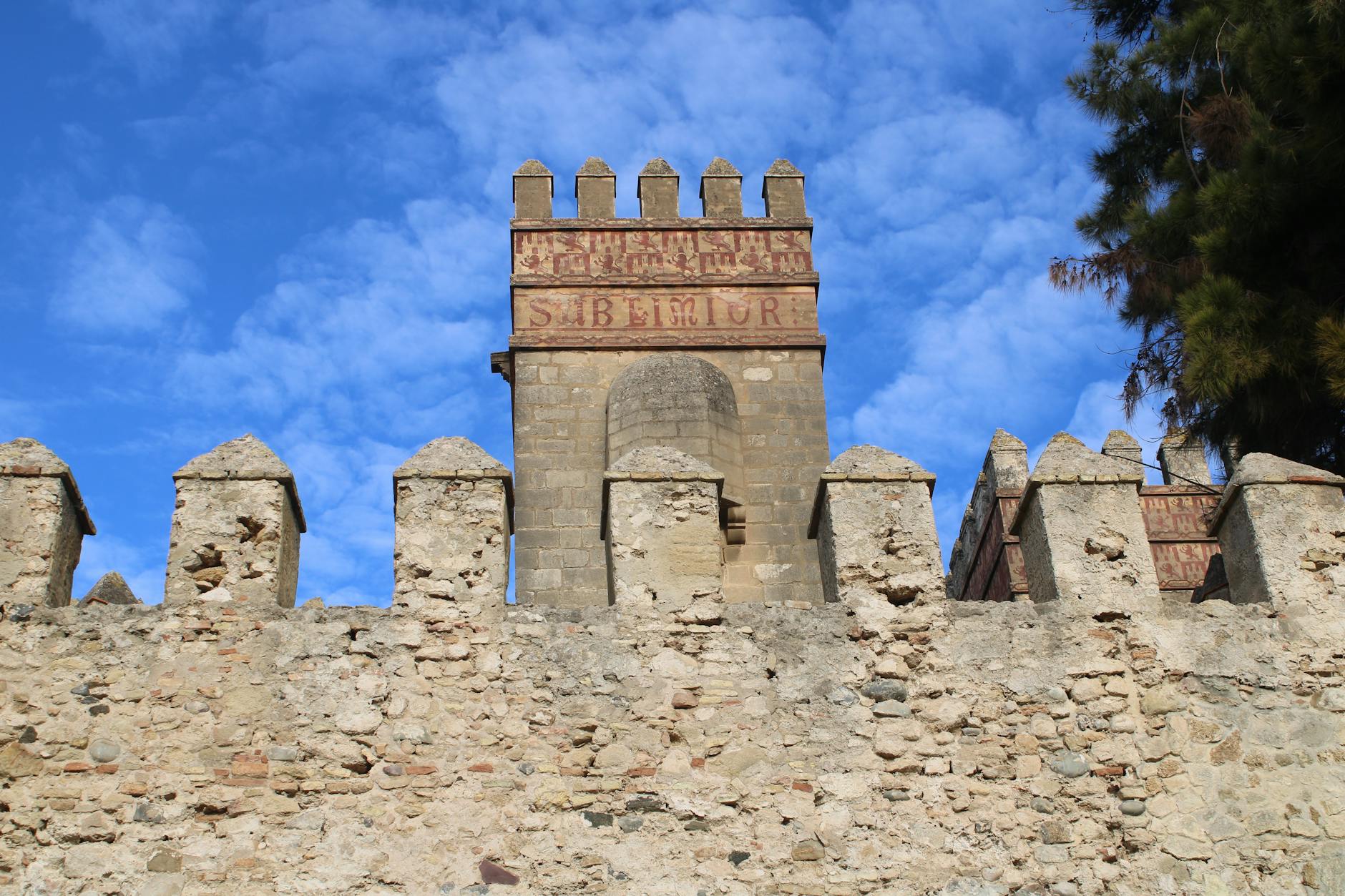 Historic fortress architecture under a clear blue sky in El Puerto de Santa María, Spain.