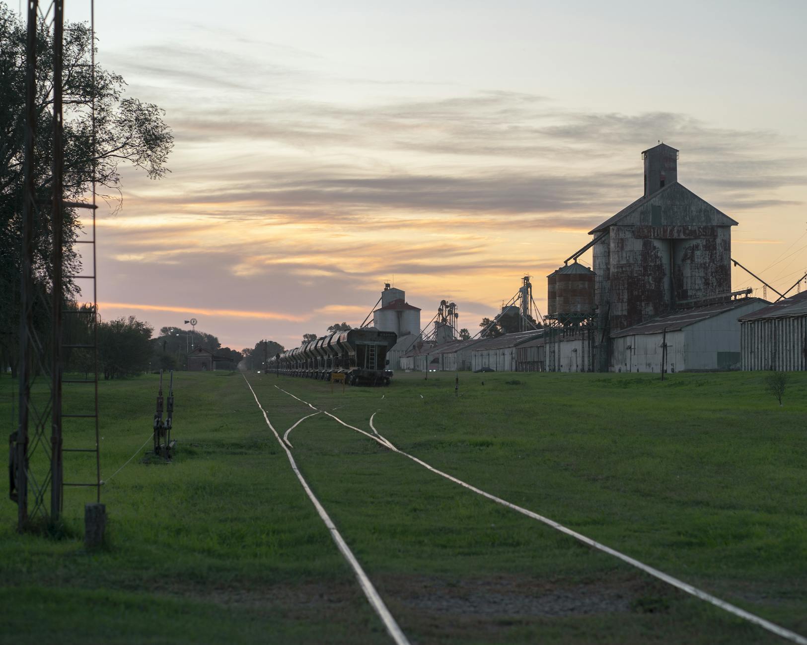 Sunset view of a serene railroad and industrial landscape in Córdoba, Argentina.
