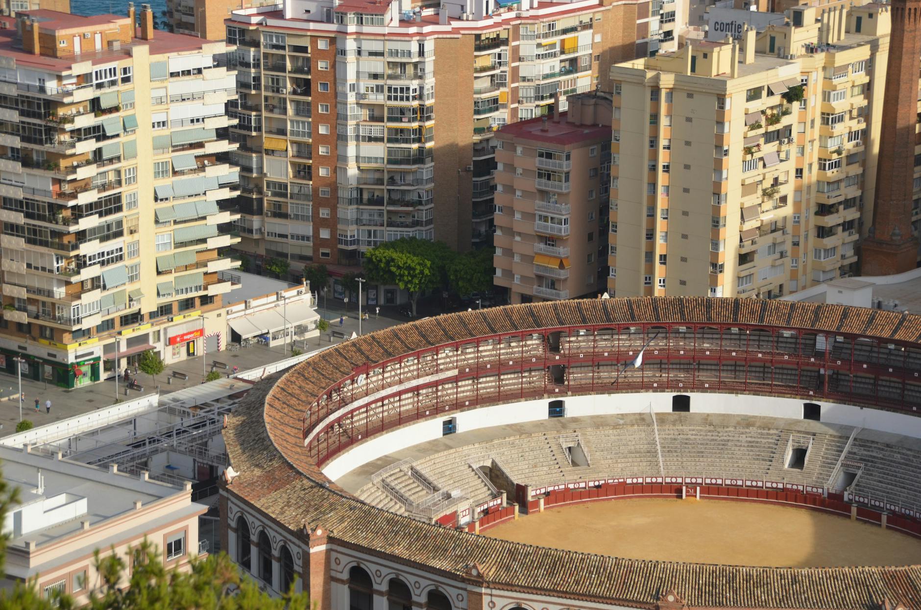 High-angle view of the iconic Plaza de Toros surrounded by urban buildings in Málaga, Spain.
