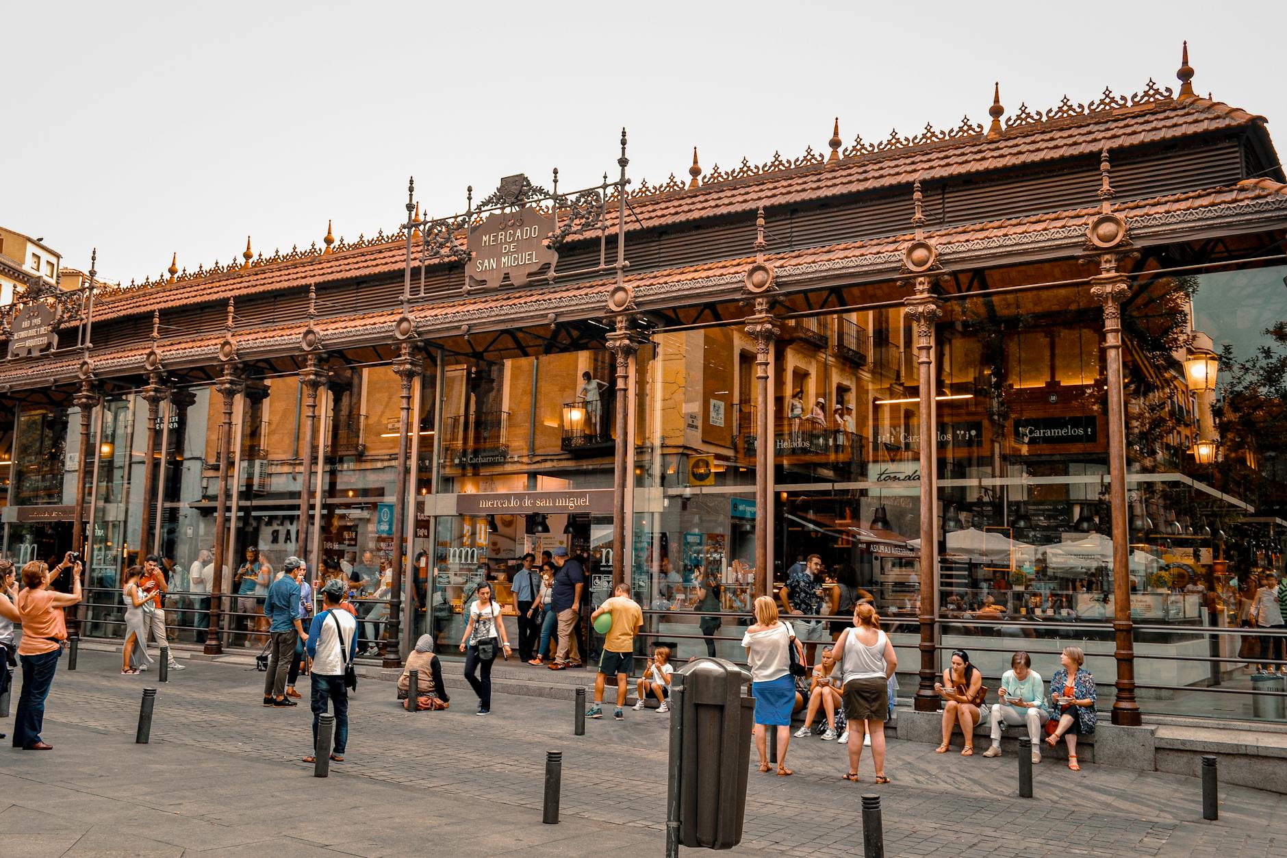Bustling activity at Mercado de San Miguel in Madrid, a popular tourist spot with iconic architecture.