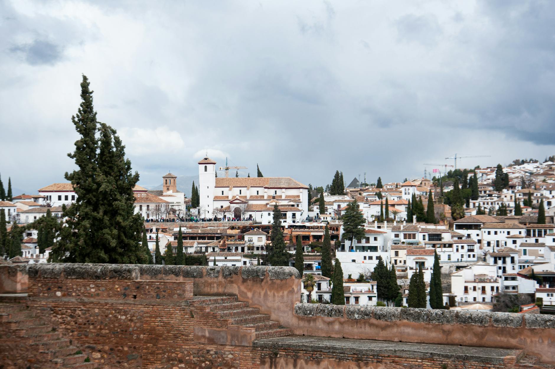 A picturesque view of Granada's traditional architecture with cloudy skies above.